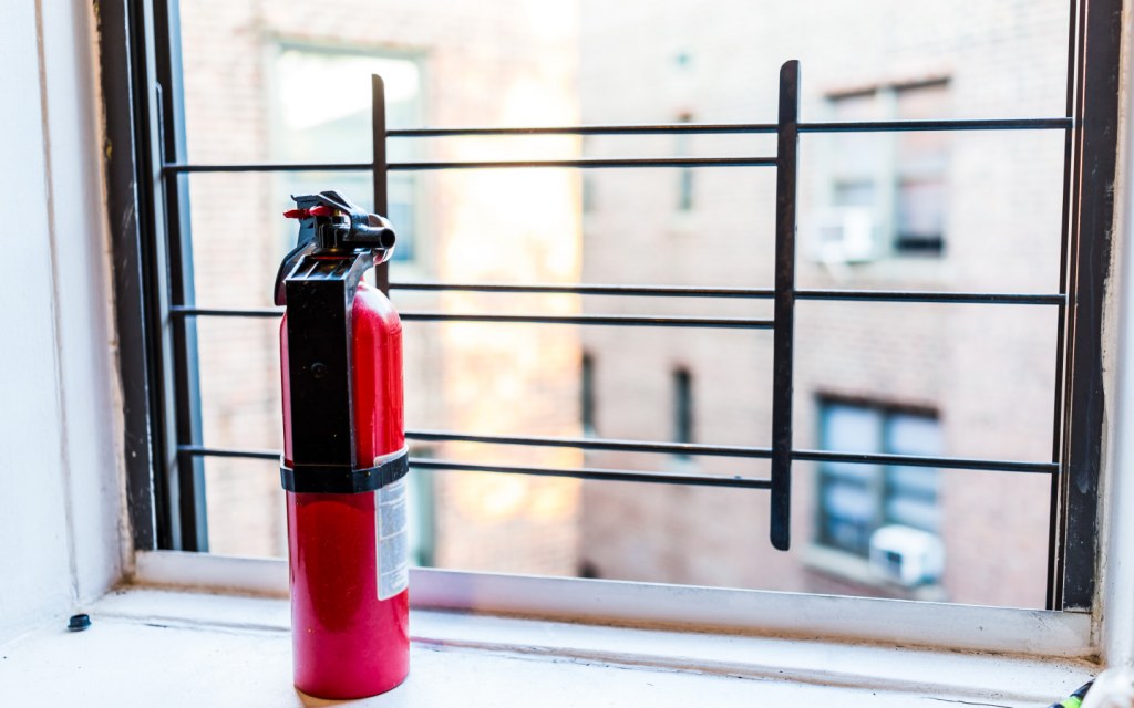 Home fire extinguisher placed on a window sill