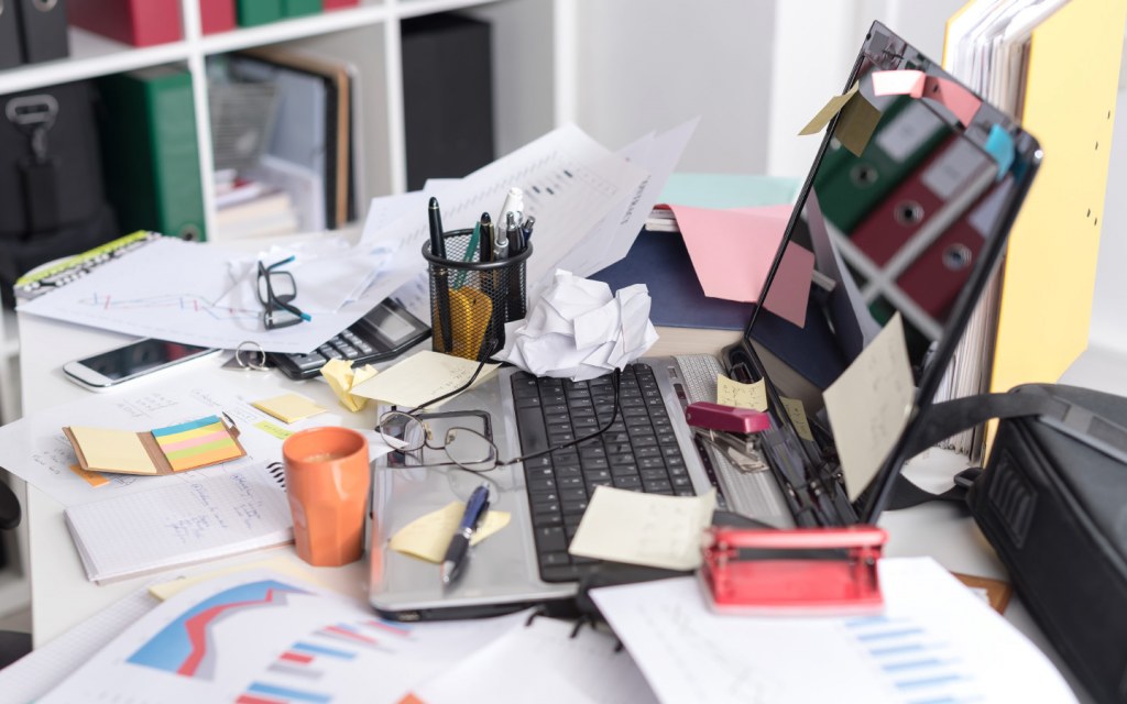Office workspace paper clutter with laptop