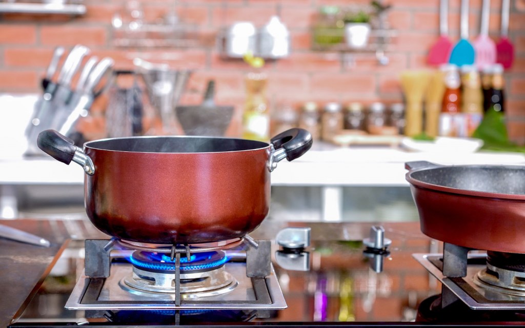 A pot sits on gas stove in a kitchen