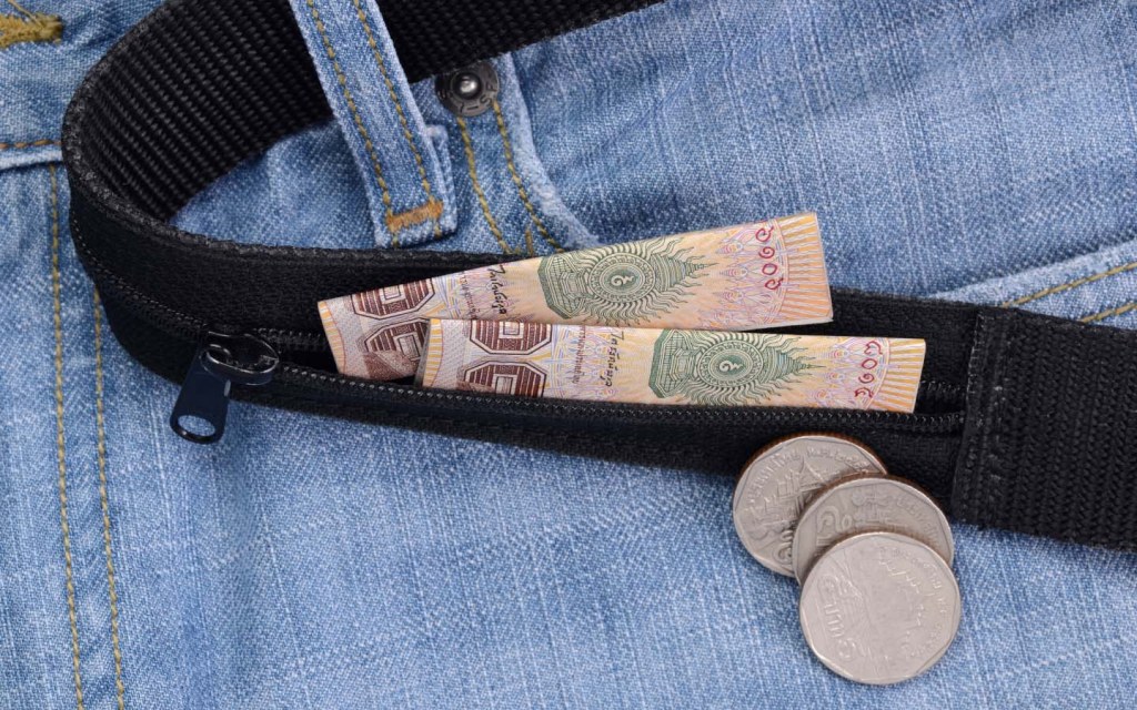 Traveller using money belt to keep cash safe
