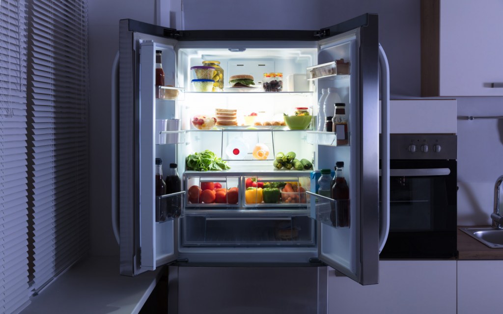 Open refrigerator full of food fruits vegetables juices