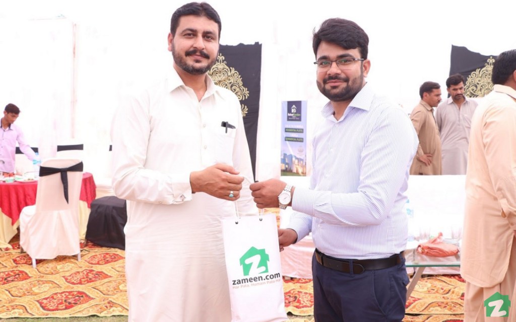 An attendee receives a giveaway at the Rahim Yar Khan event