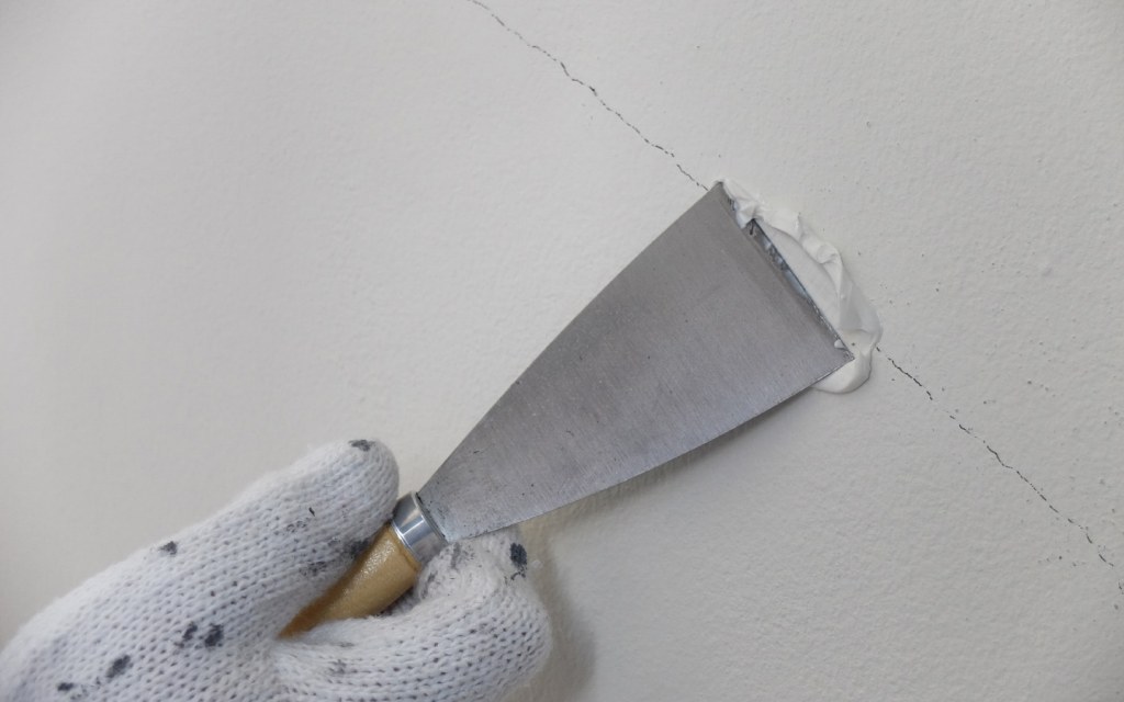 Fill in cracks on the walls using putty mixture